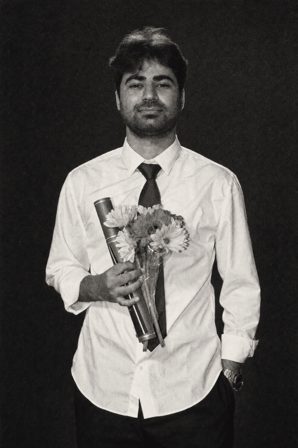 Archival black-and-white portrait of Mohtasham Murshid Madani holding flowers and a rolled document.